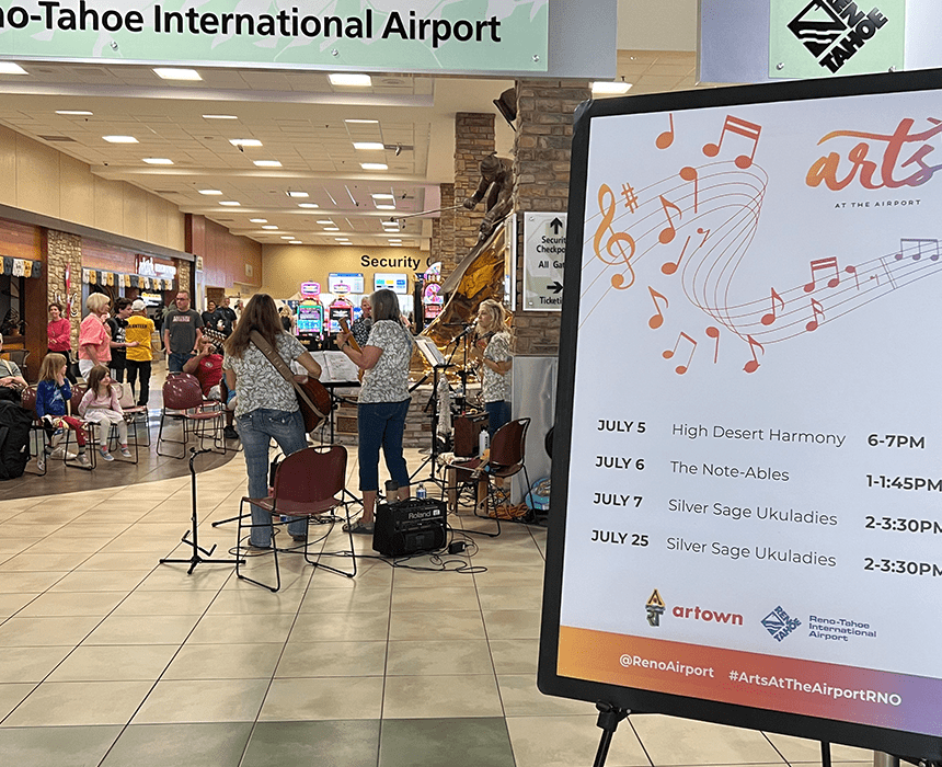 Arts at the Airport poster with band playing in the background