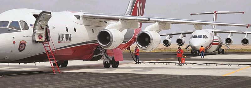 Crews load one BAE-146 with fire retardant while another waits its turn.