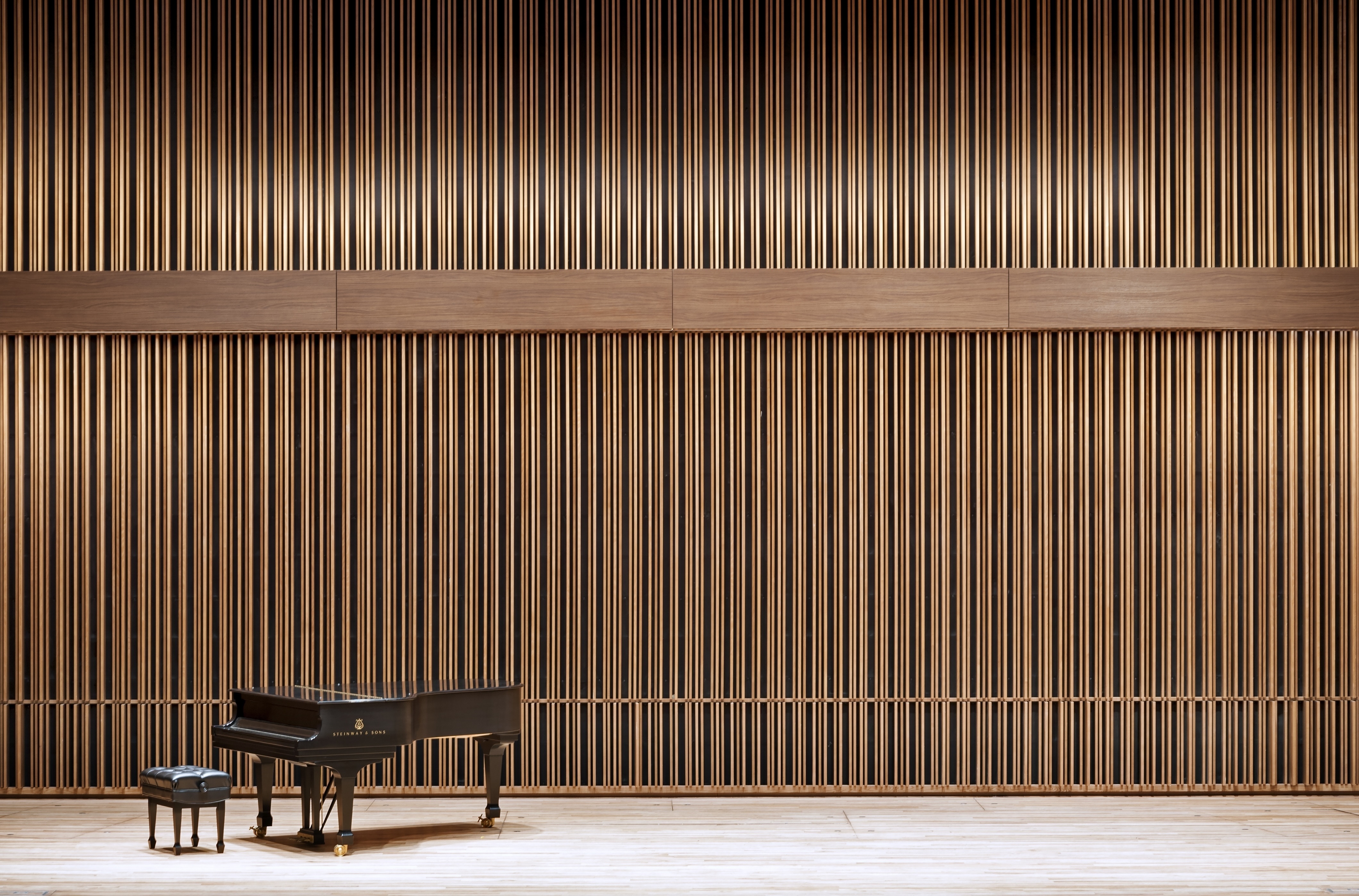Geometrik wood acoustical wall in concert hall with a piano